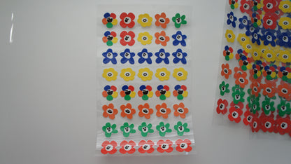 Colorful flower-shaped stickers on a white background